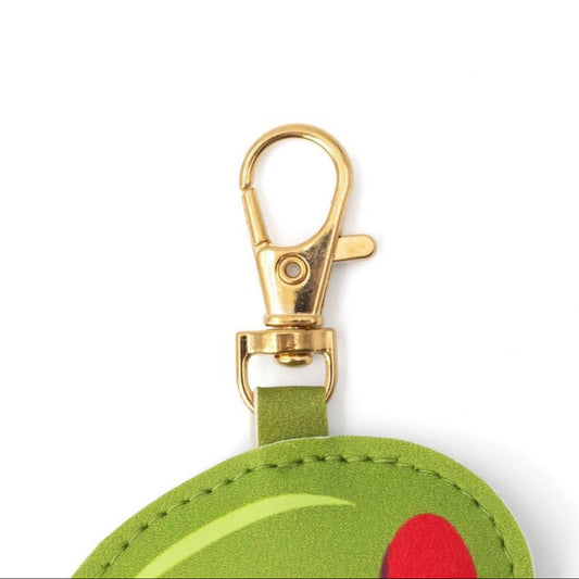 Close-up detail of olive keychain with gold hardware and martini-inspired accessory design.
