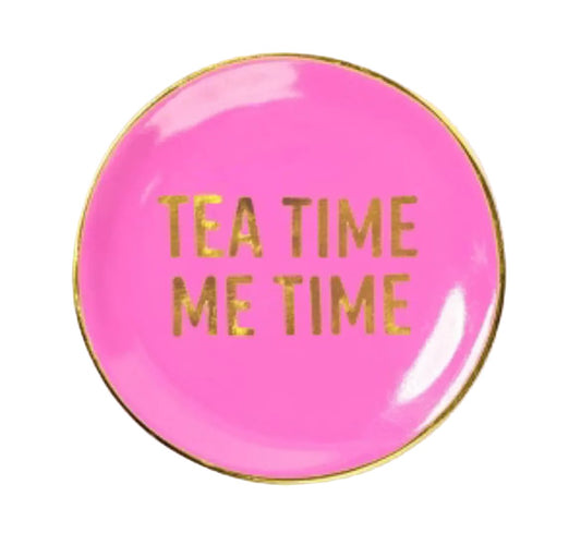 A round pink enamel pin or badge with a gold border and the text 'TEA TIME ME TIME' in gold foil lettering, shown on a white background.