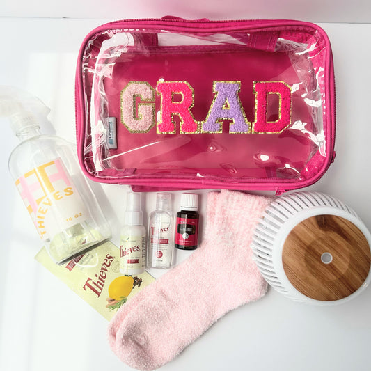 Self-care graduation gift bundle with diffuser, Thieves wellness products, grapefruit essential oil, cozy socks, and reusable grad travel pouch for college students.
