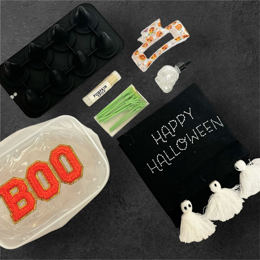 Orange BOO Halloween Wellness Gift Bundle with Happy Halloween towel, pumpkin spice lip balm, skull bottle, ice mold, hair clip and seasonal accessories.