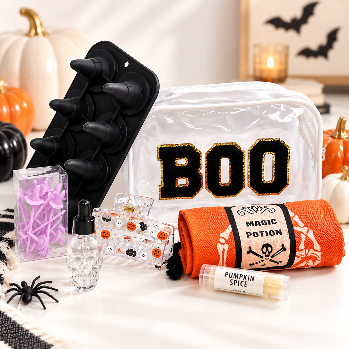 Halloween Wellness Gift Bundle with BOO bag, pumpkin spice lip balm, skull essential oil bottle, Halloween accessories and seasonal gift items styled with pumpkins.