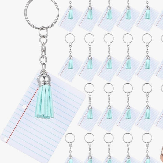 Close-up of the Vinyl & Oil mini notebook keychain with mint tassel showing the writable pages and compact design for teacher gifts and classroom favors.