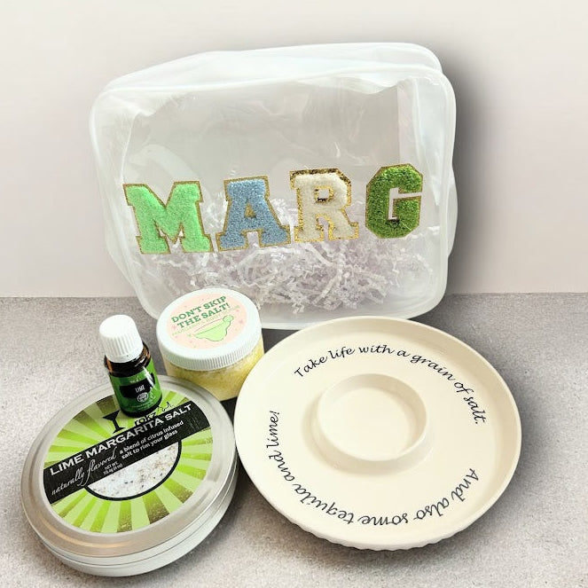 Margarita wellness gift bundle with lime margarita salt, body scrub, lime essential oil, ceramic salt rimmer, and reusable gift pouch.