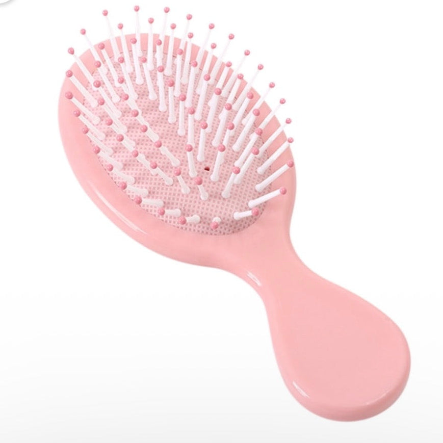 Pink mini detangling hair brush, a colorful self-care accessory for a custom wellness gift bundle.