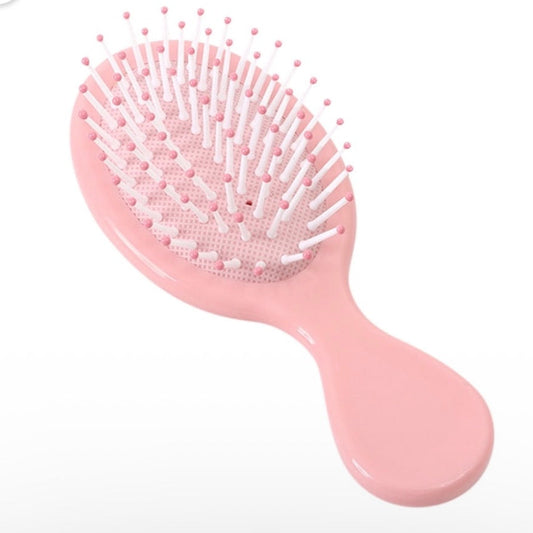 Pink mini detangling hair brush, a colorful self-care accessory for a custom wellness gift bundle.