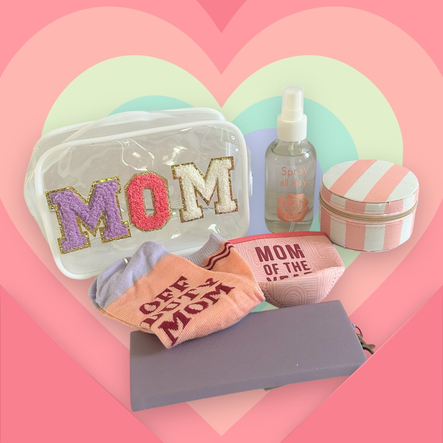 Mom wellness gift bundle featuring a clear MOM cosmetic bag, self-care accessories, socks, and beauty essentials on a pastel rainbow heart background.
