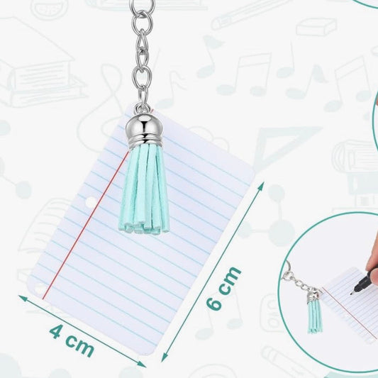 Close-up of the Vinyl & Oil mini notebook keychain with mint tassel showing the writable pages and compact design for teacher gifts and classroom favors.