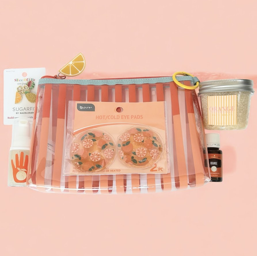 Citrus self-care gift set with orange essential oil, hot and cold eye pads, bath salts, hand sanitizer and bag charms